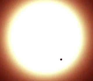 vue d'artiste du transit de CoRot-7b devant son étoile. On est capables de mesurer nettement la baisse de luminosité...